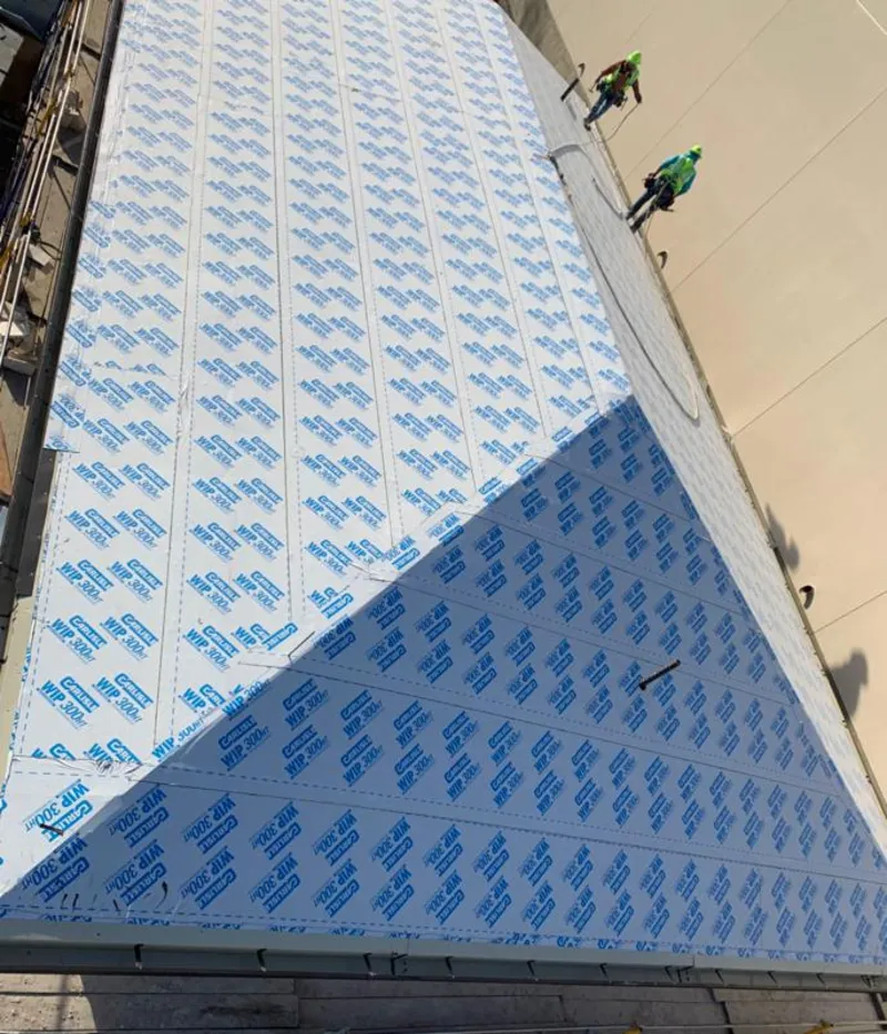 Professional roofers installing underlayment on a metal roof in Dinuba